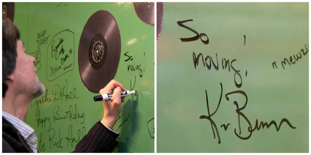 A close-up showing Ken Burns signing the Green Board with a dry-erase marker, and then a detail of what he wrote: "So moving! Ken Burns".