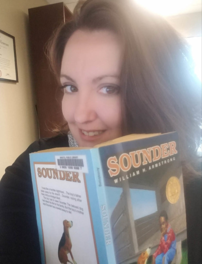 Selfie of Amy Kimani peeking over the top of her copy of Sounder